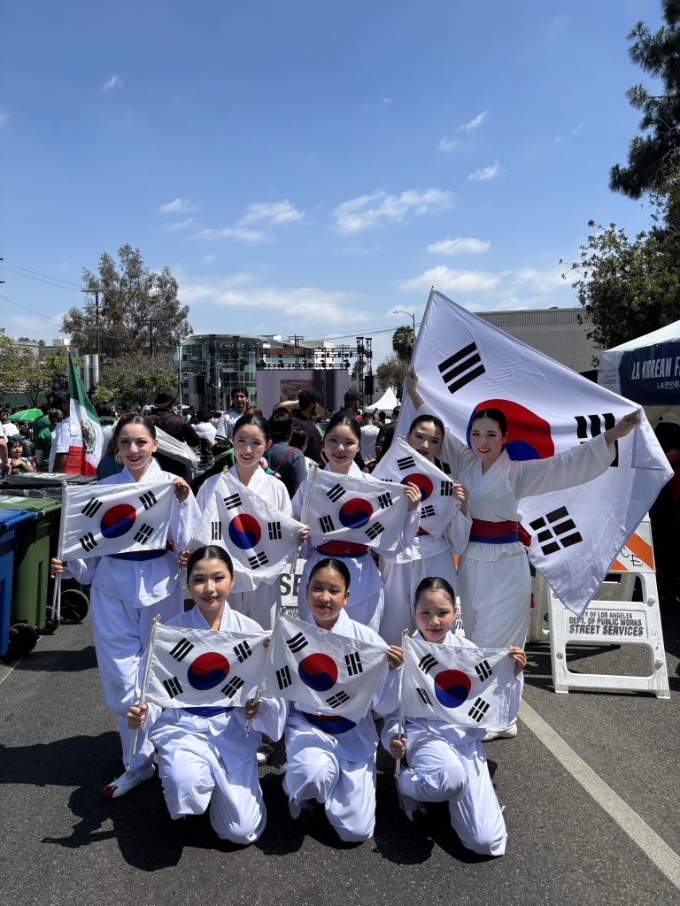 Portrait of Kim Eung Hwa Korean Dance Company members holding Korean flags